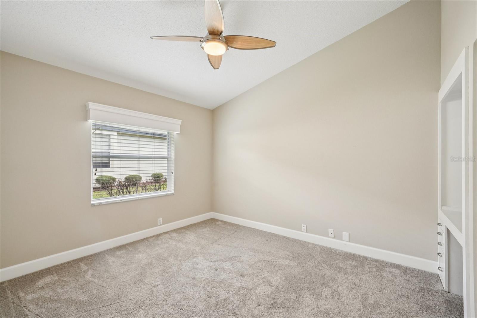 Bedroom two features vaulted ceilings, new carpet, built-in desks, wall closets, and modern ceiling fans.