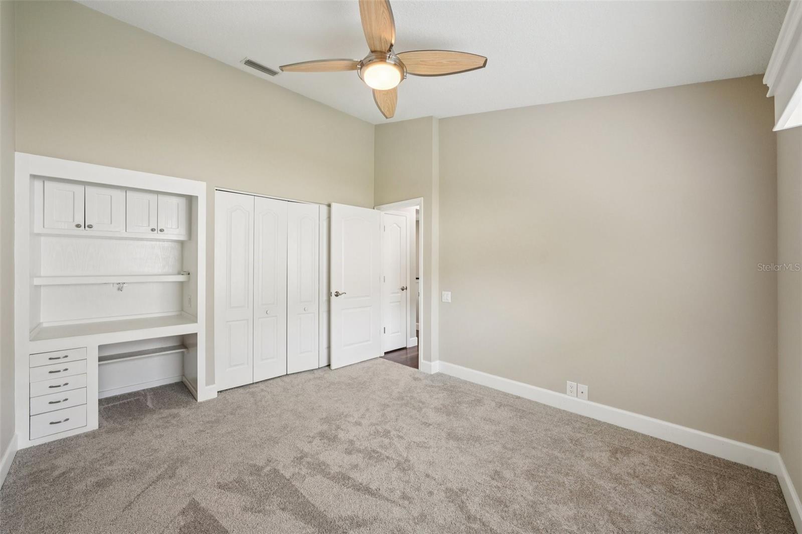 Bedroom two features vaulted ceilings, new carpet, built-in desks, wall closets, and modern ceiling fans.