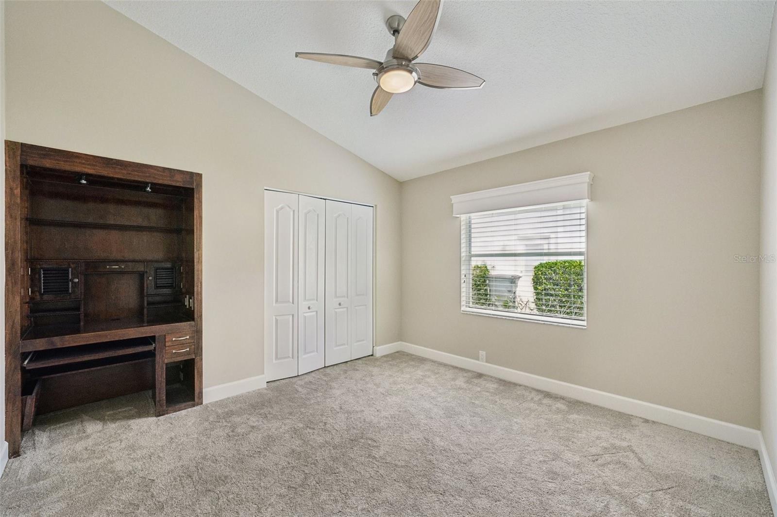 Bedroom three features vaulted ceilings, new carpet, built-in desks, wall closets, and modern ceiling fans.