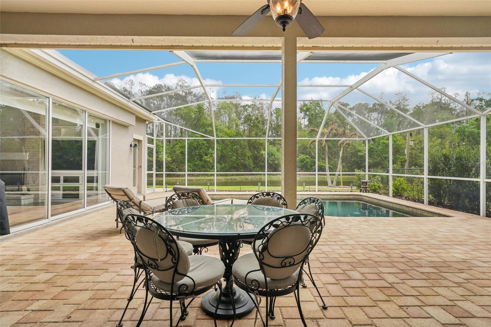 Enjoy everyday Florida living with glass sliders from multiple rooms opening to a screened pool and patio retreat. The sparkling Pebble Tec pool and surrounding paver deck with covered outdoor space offer a perfect place to relax, dine or gather with a tranquil pond and conservation backdrop. The landscaping provides privacy while preserving the view, with frequent wildlife sightings add to the natural appeal.