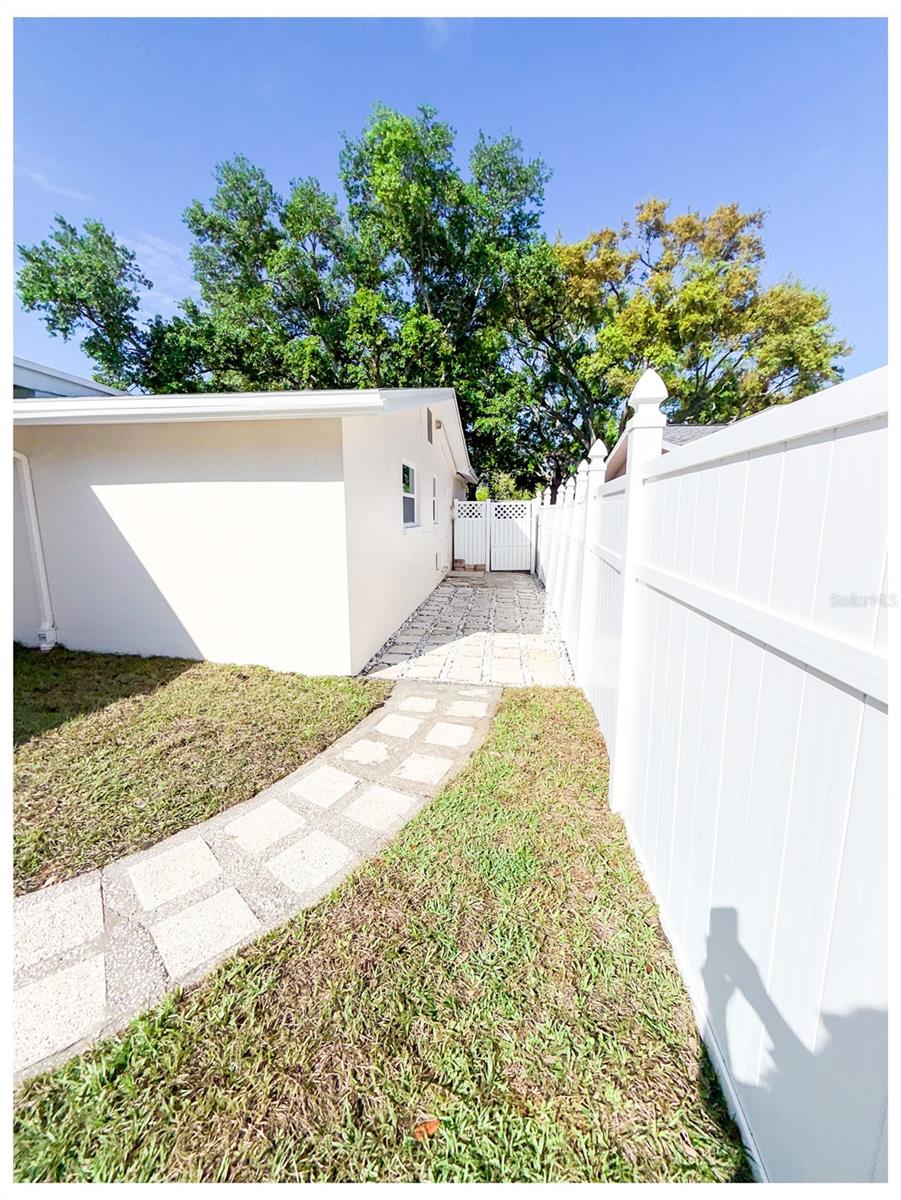Walkway towards garage and front yard from the backyard.