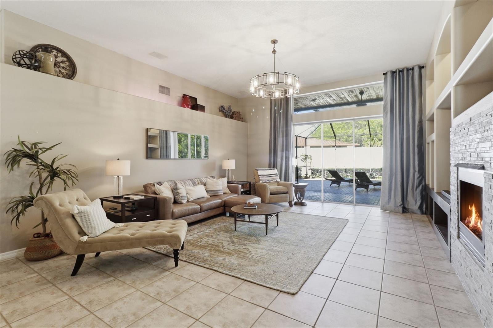 Open living room adjacent to the kitchen, featuring abundant natural light and views of the pool -perfect for indoor-outdoor living