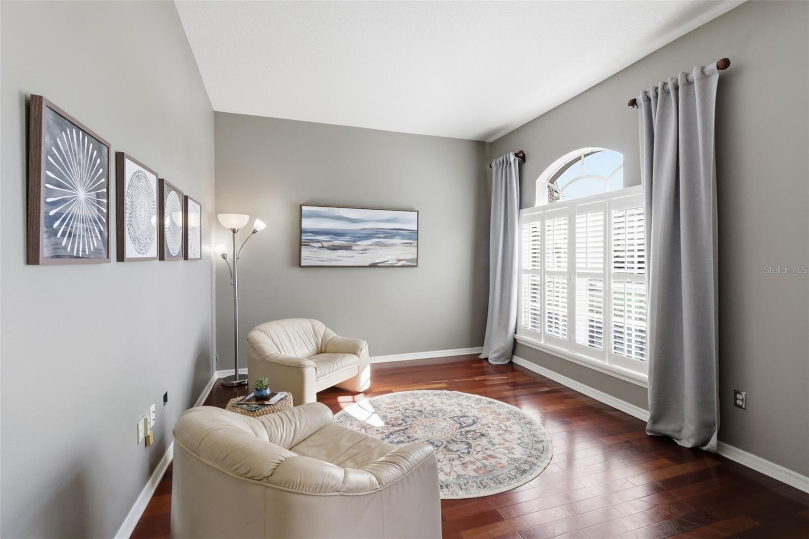 Elegant sitting area off the entry featuring wood floors and abundant natural light