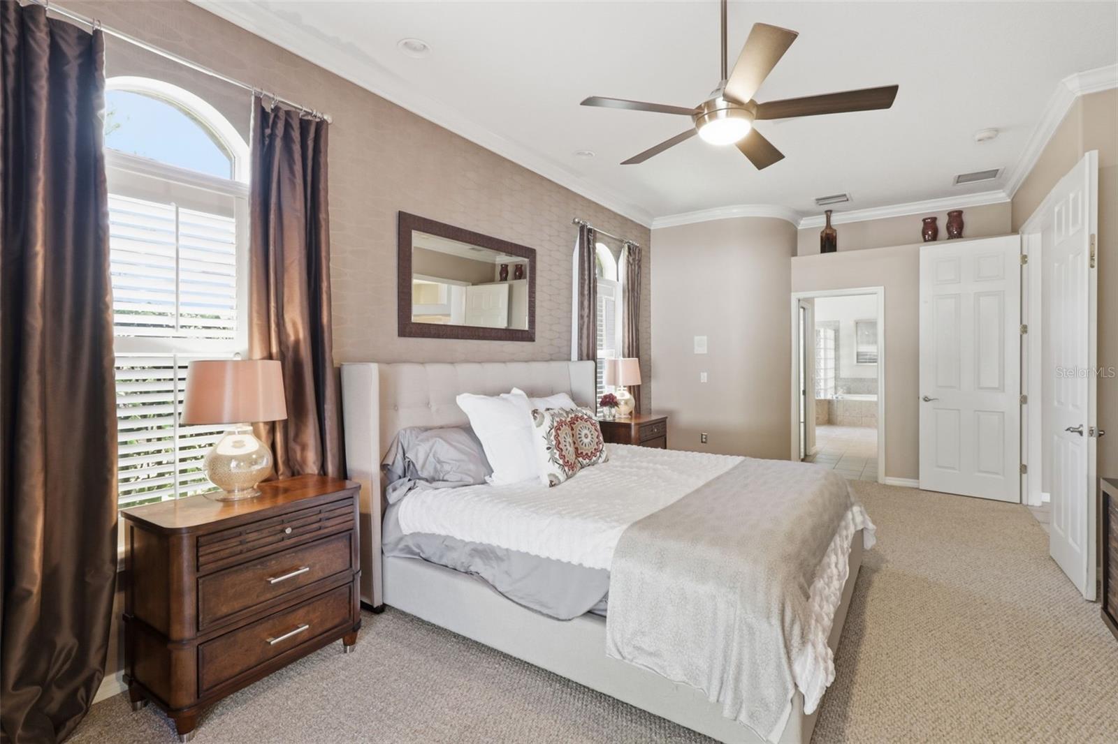 Alternate view of the spacious primary suite showcasing natural light and direct access to the pool