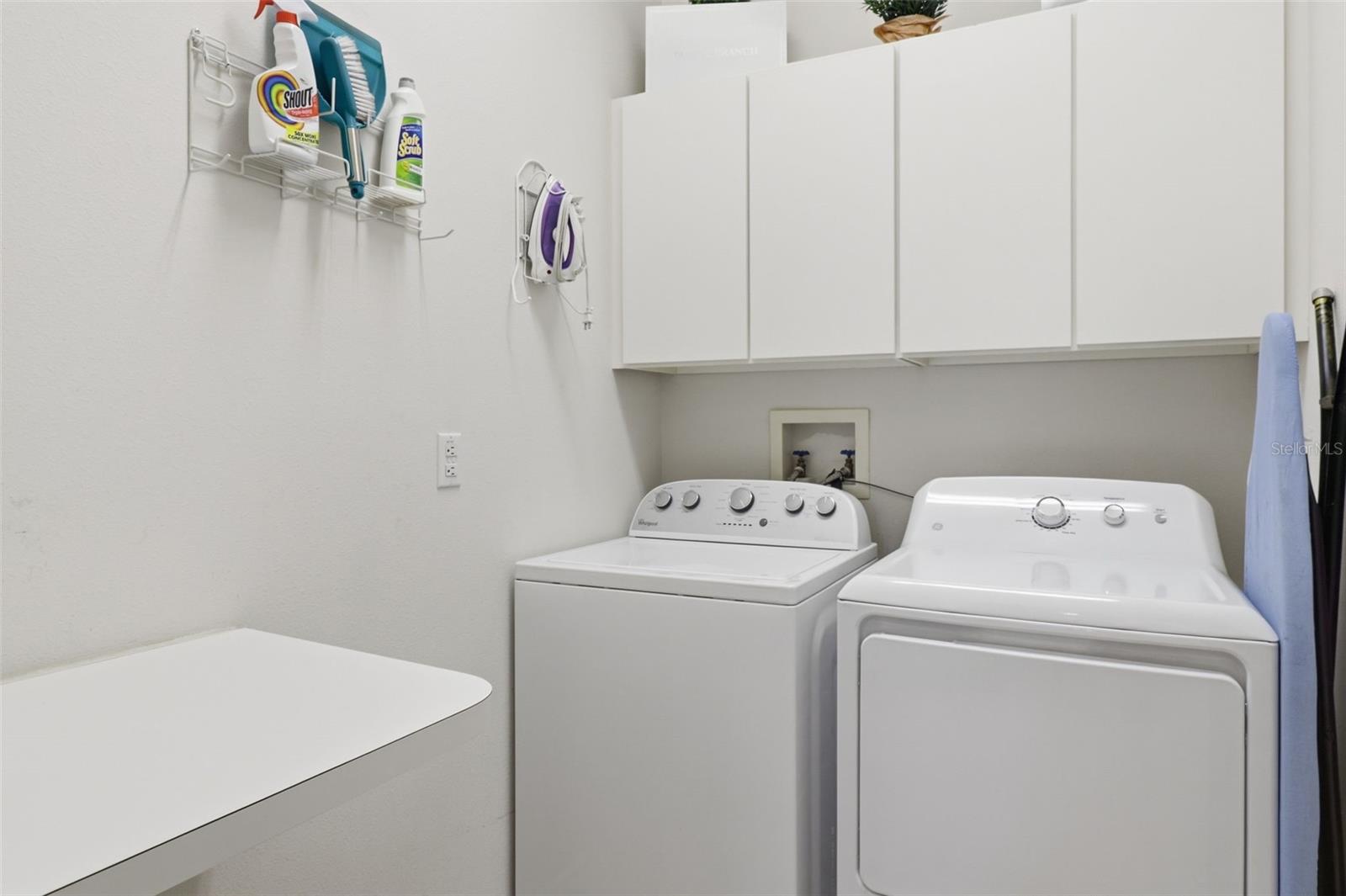 Convenient laundry room featuring washer, dryer, and additional storage cabinets