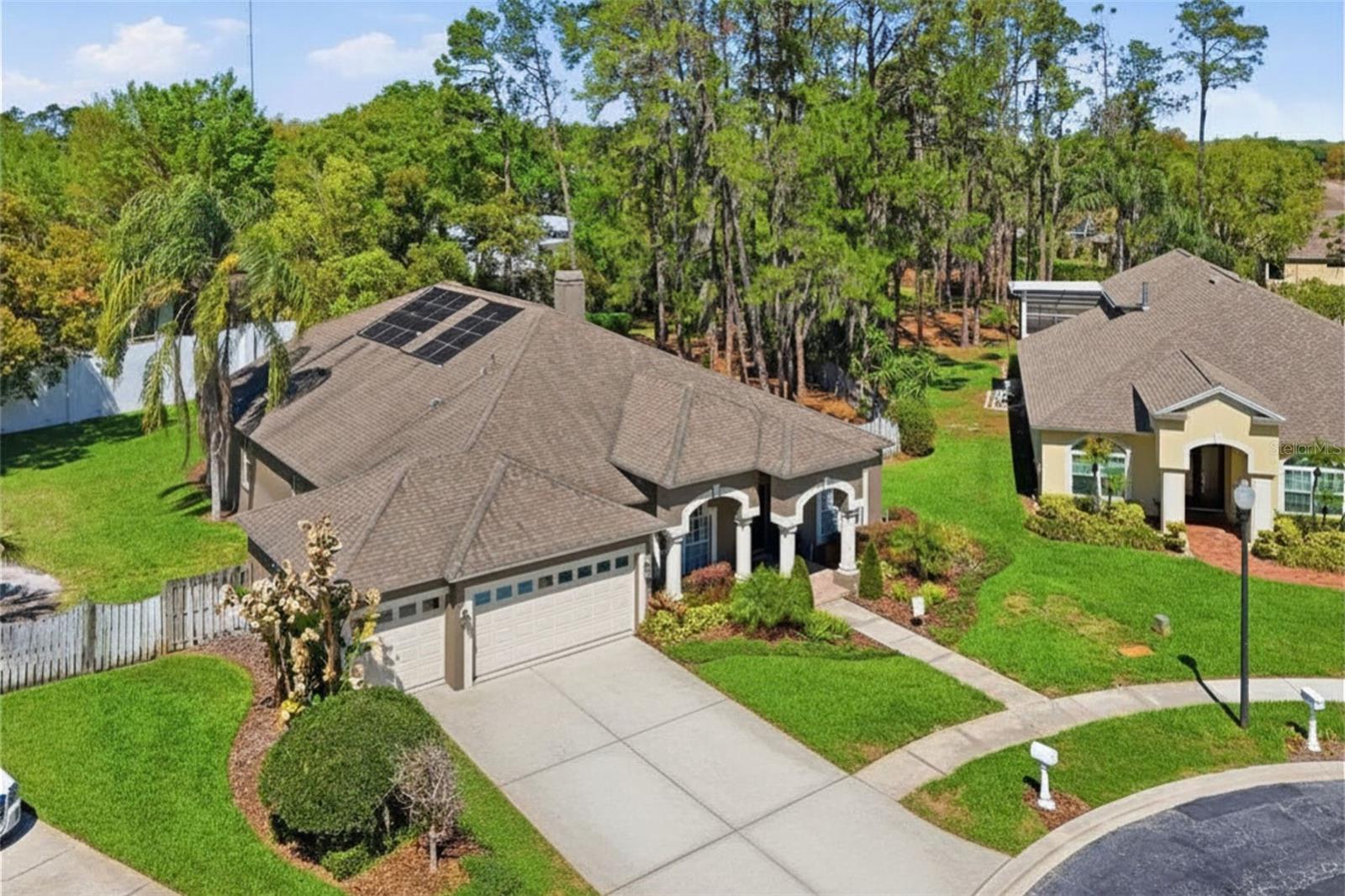 Aerial view highlighting the home’s curb appeal, expansive lot, and established neighborhood setting