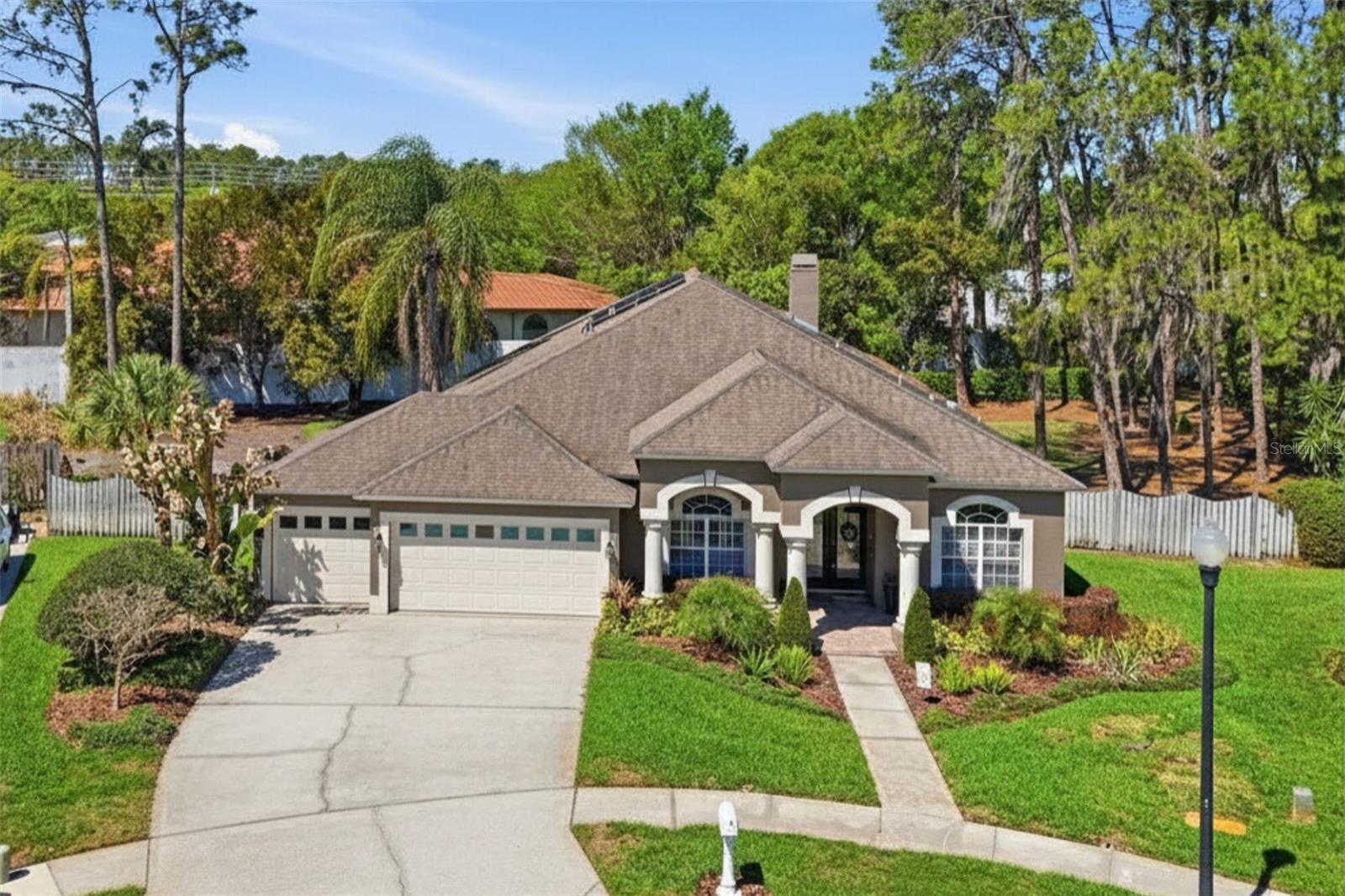 Aerial view showcasing the home’s curb appeal, spacious lot, and surrounding landscape