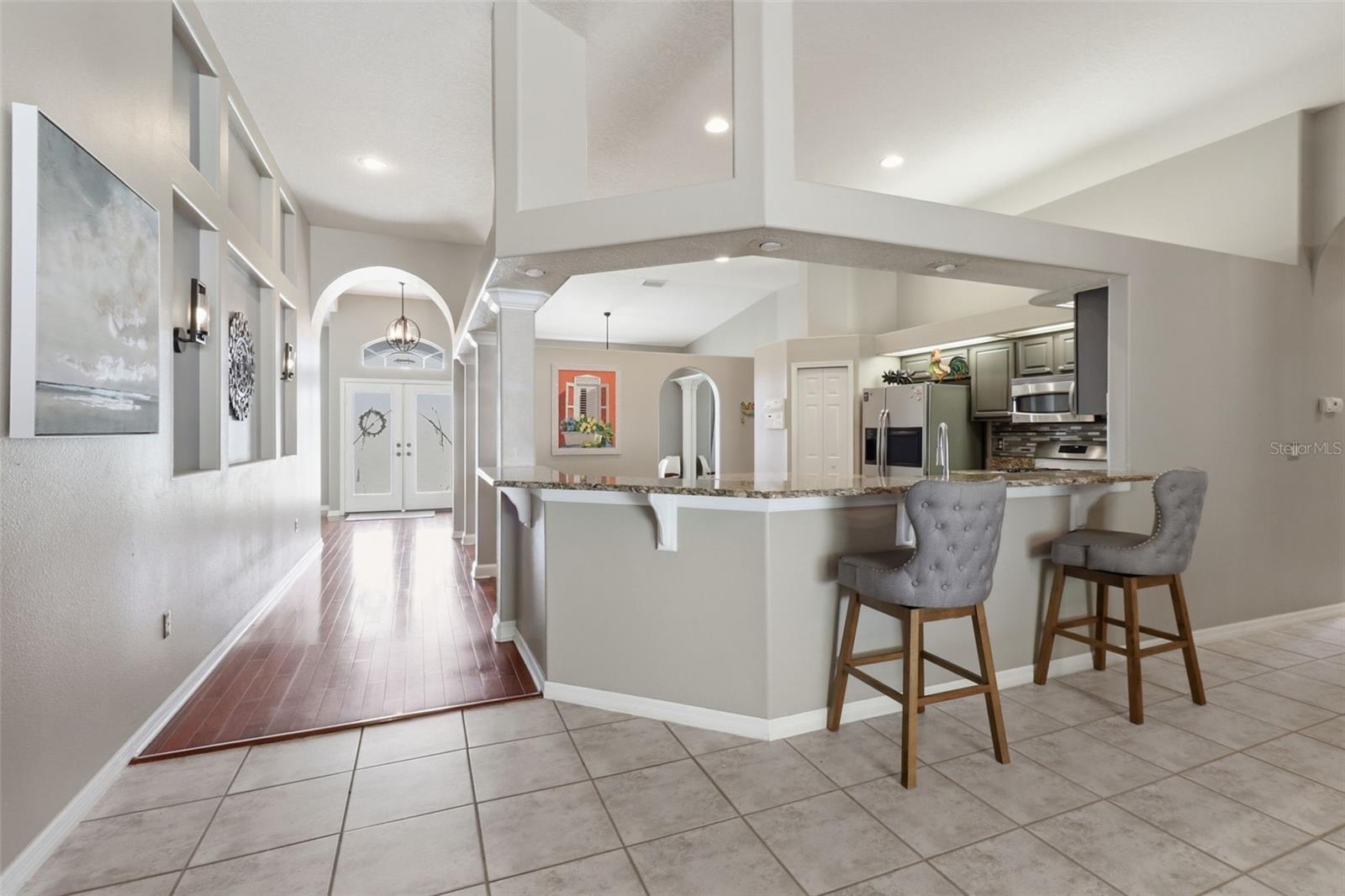 Bright, open entry flowing into a spacious kitchen with granite breakfast bar and plenty of room to cook and gather
