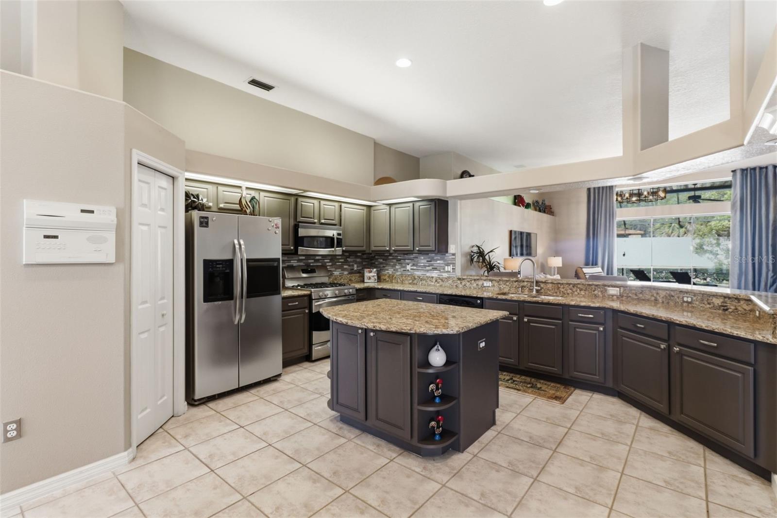 Spacious kitchen featuring granite countertops, stainless steel appliances, and a large center island for prep and gathering