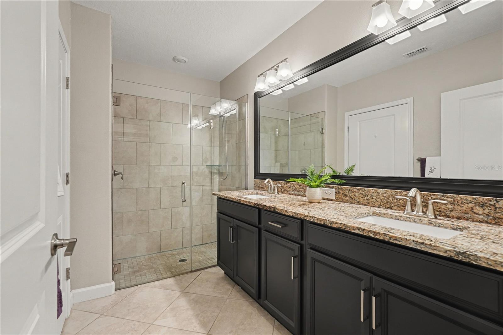 Bath ensuite with Granite counters, framed mirror and large shower