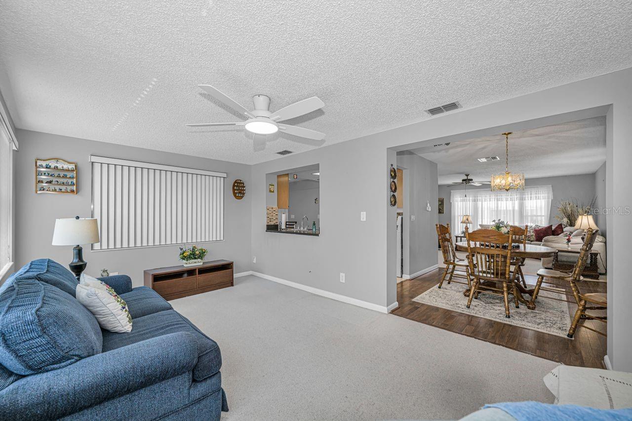 Looking into the dining area, kitchen, and living room beyond.