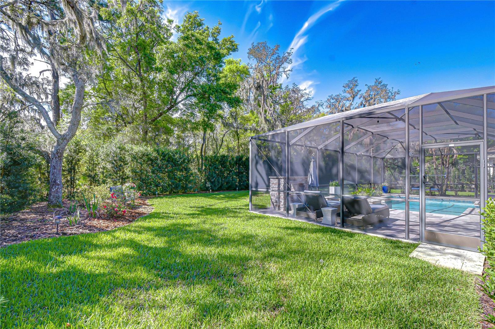 Fully fenced yard with lush privacy landscaping.