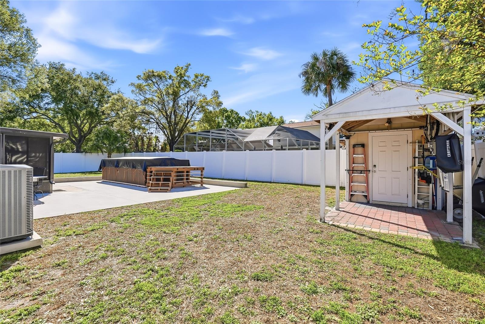Spacious backyard with swim spa and shed for additional storage.