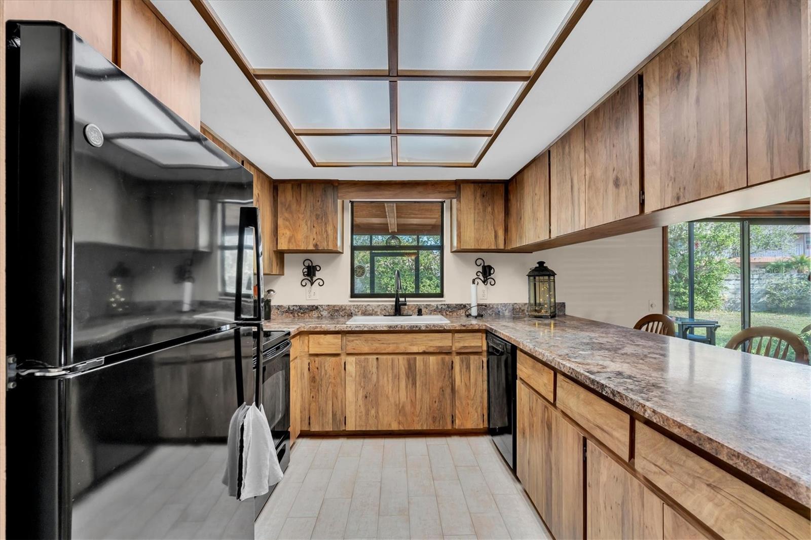 Kitchen has tiled floors and black appliances including Dishwasher, Microwave, Range, and Refrigerator