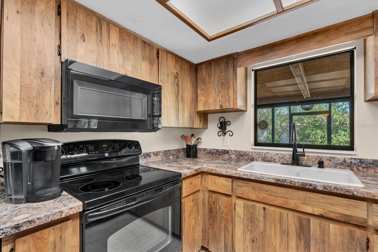 Kitchen has tiled floors and black appliances including Dishwasher, Microwave, Range, and Refrigerator