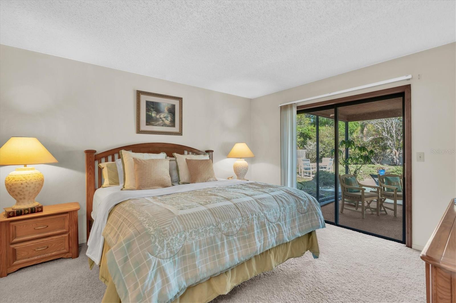 Primary Bedroom with Walk-in closet, dressing area, sliders leading to screened porch, and ensuite bath