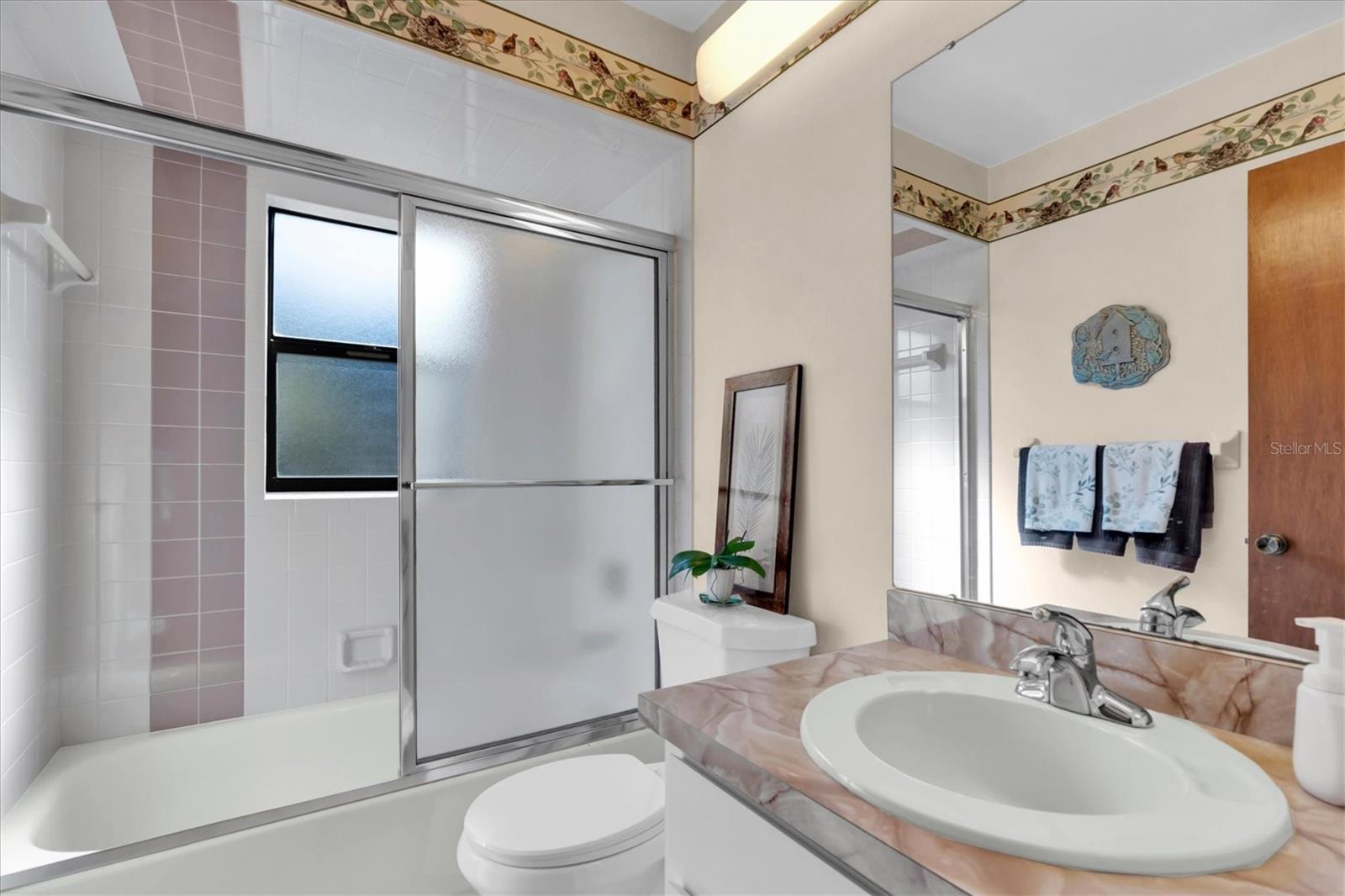 Bathroom 2 with tiled tub/shower combo and tiled floors