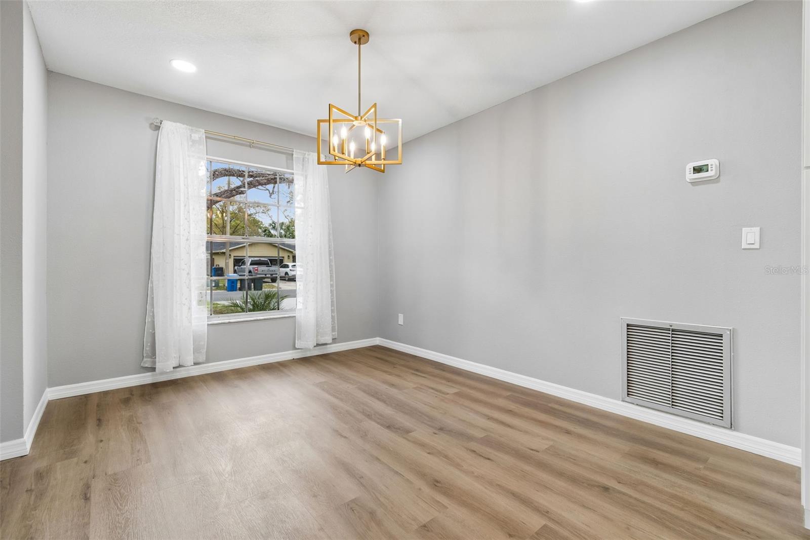 Dedicated dining space with large window, modern light fixture, and wood-look flooring, conveniently located near the main living areas.