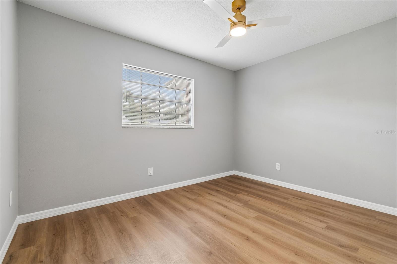 One of the smaller bedrooms with ceiling fan, and natural light from the window.