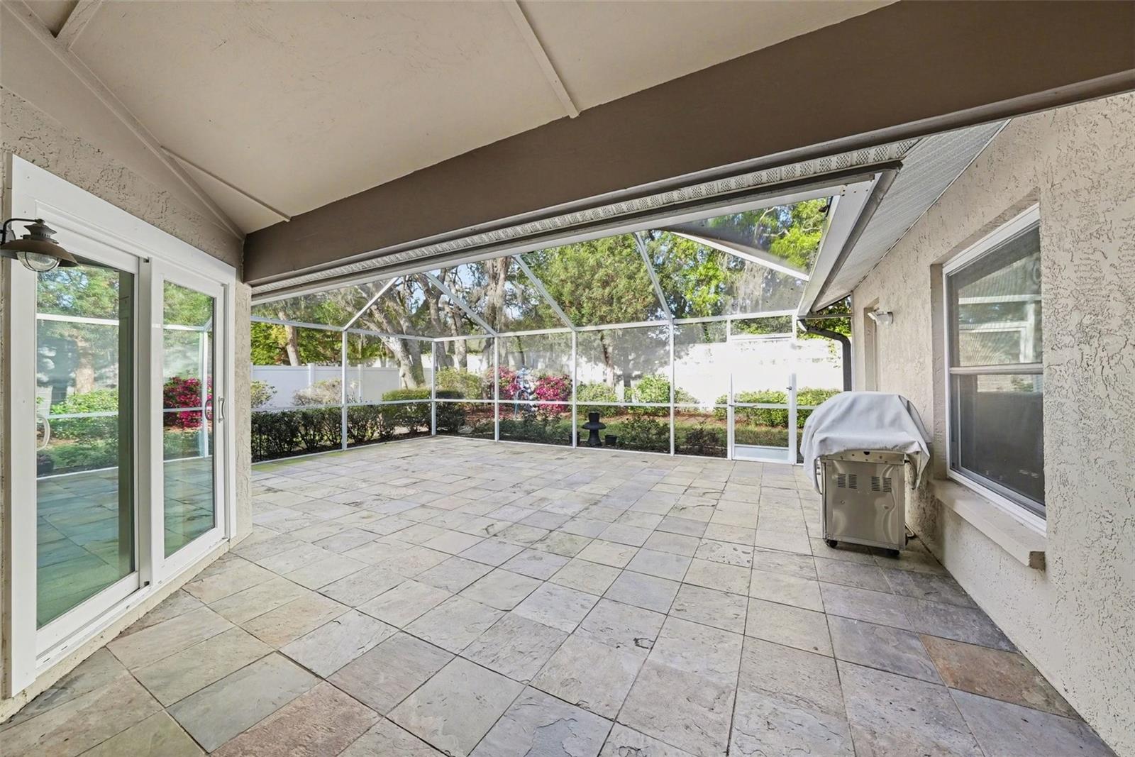 Covered and screened, this enormous outdoor oasis is ready for entertaining!