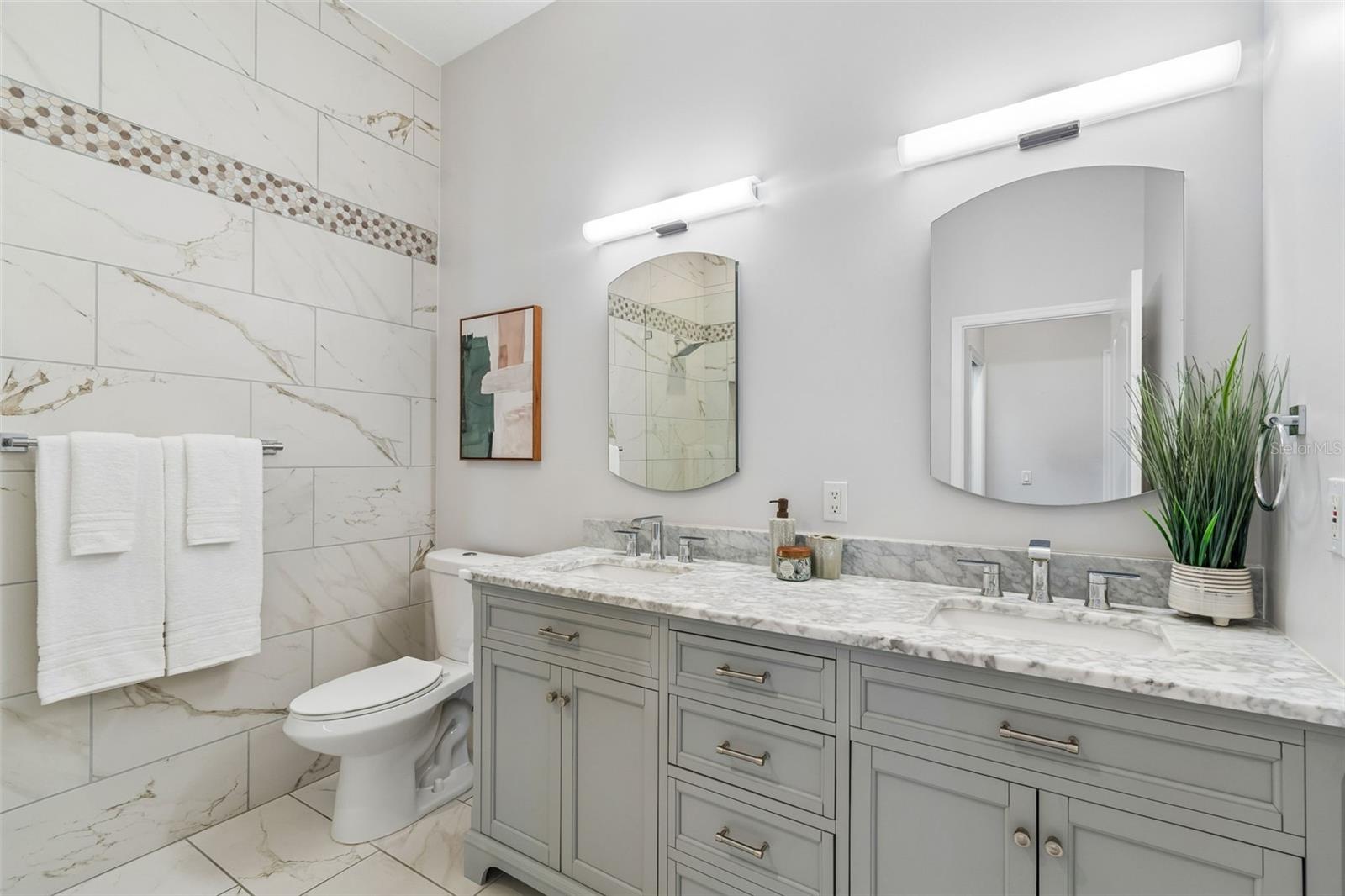 Fully Updated Secondary Bathroom with Tile Wall, Updated Lighting & Mirrors