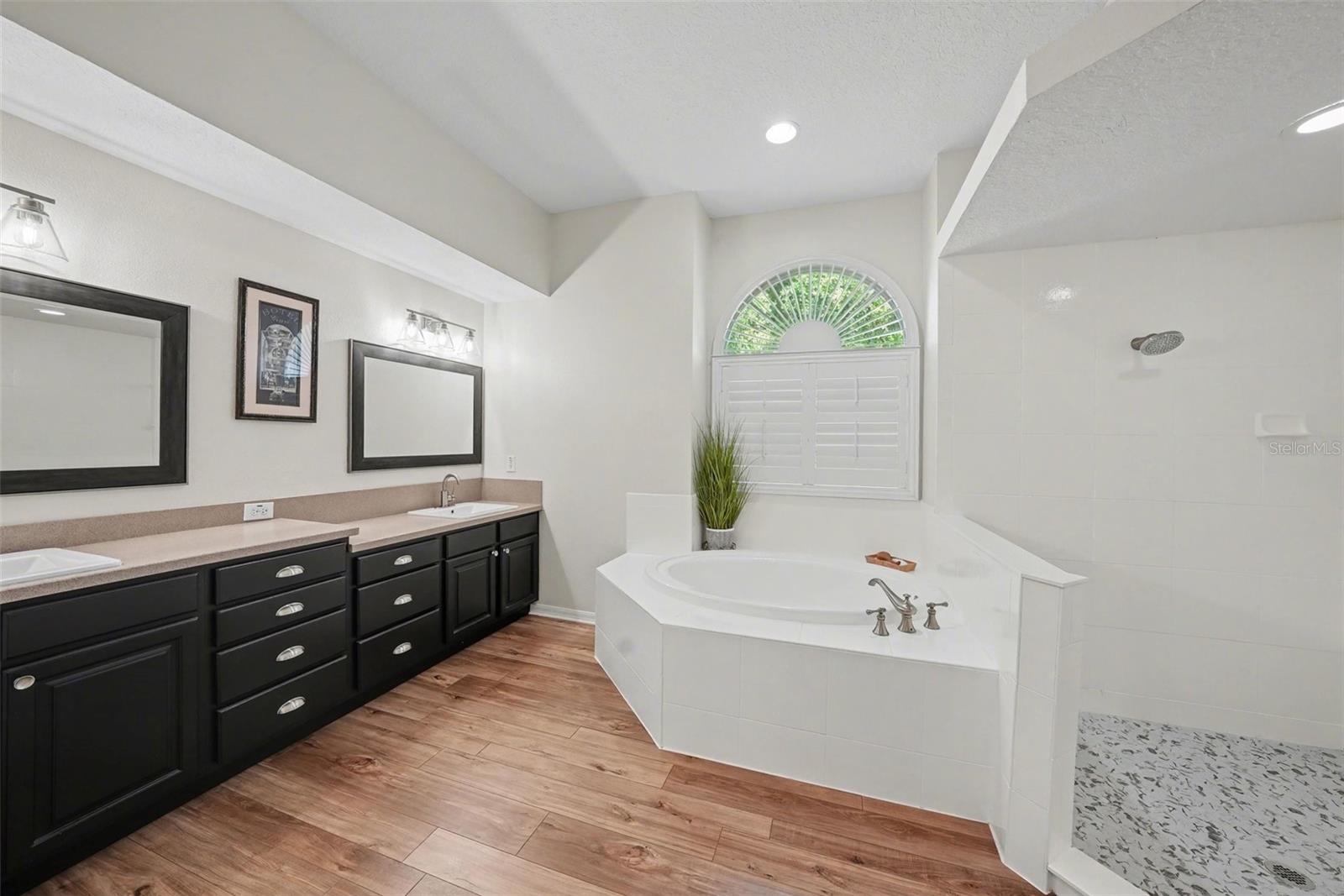 The primary bath has been tastefully updated with walk in shower, garden tub, and dual sinks.