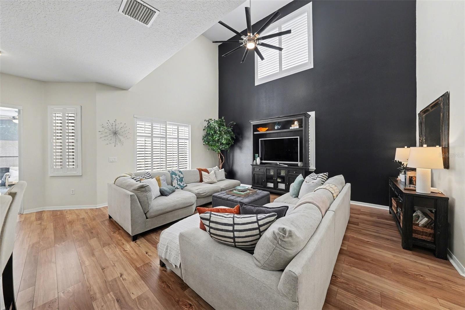 This grand room features solar plantation shutters with pool and patio views.