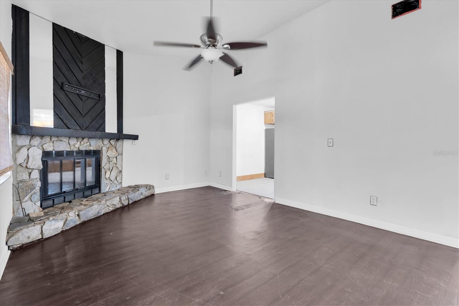 View entering living room toward the kitchen. Bedrooms are to the right
