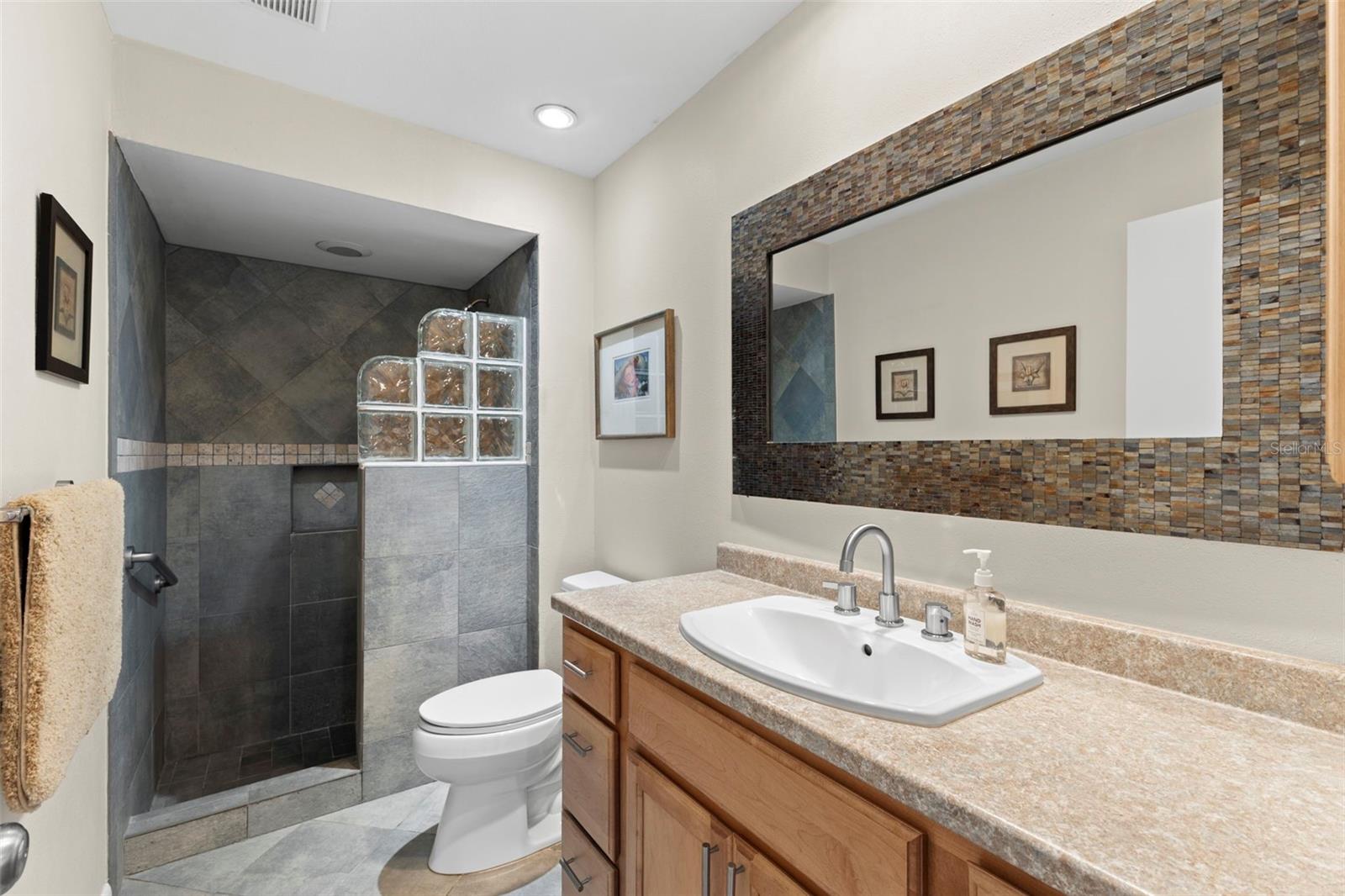 Third bath with step-in shower - located off hall by fourth bedroom