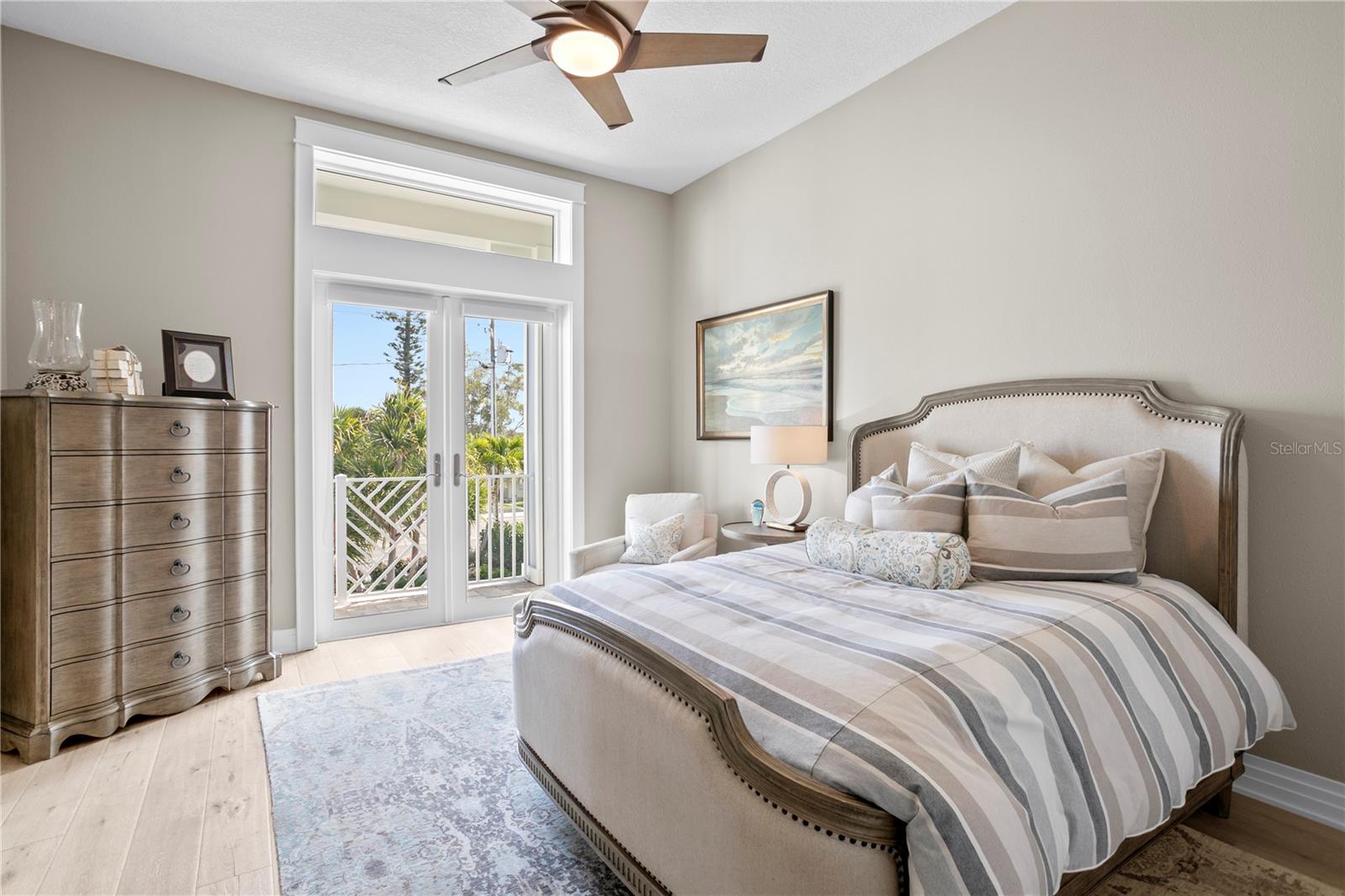 A lovely guest room on the main living level enjoys a private balcony and en suite bath