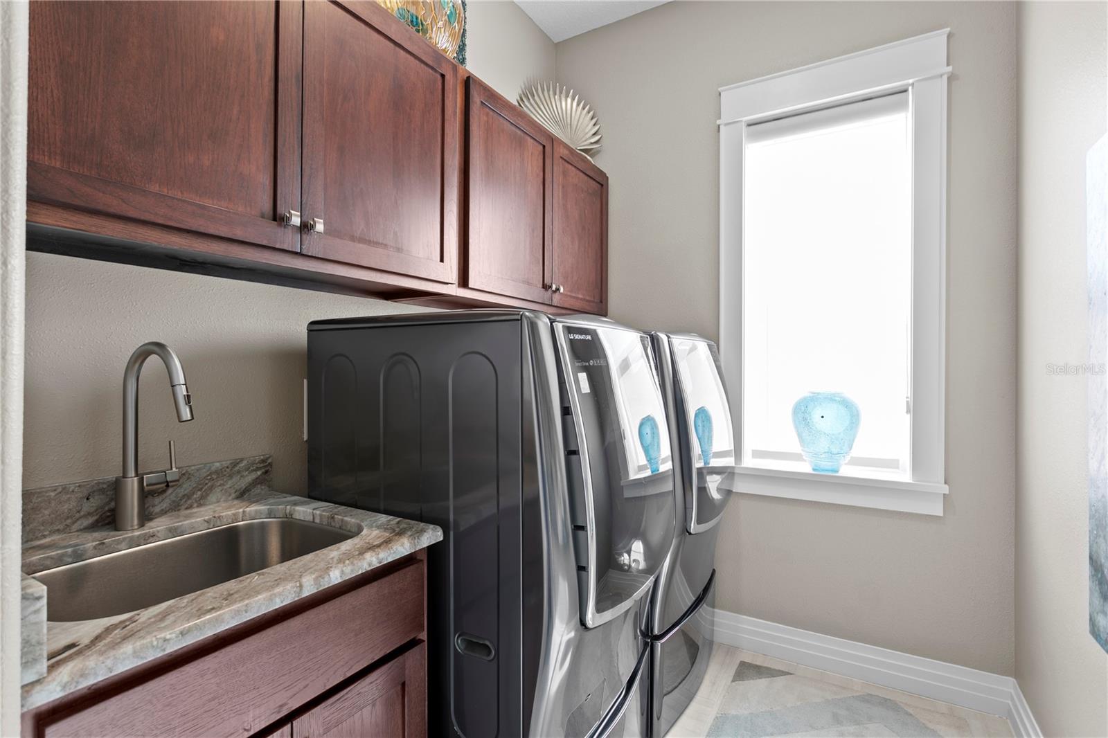 Laundry is made fun with loads of storage, utility sink and a window allowing the sunshine in every day!