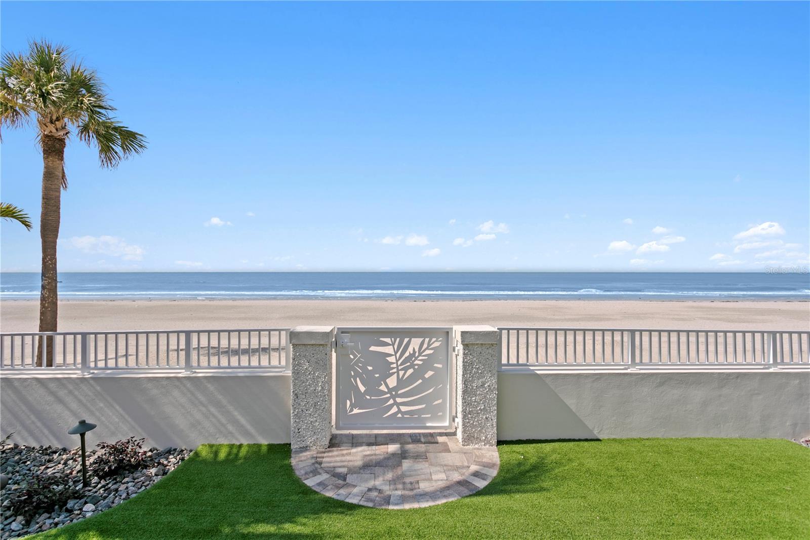 A solid concrete seawall and custom gate and tabby shell columns makes access to and from the beach easy.