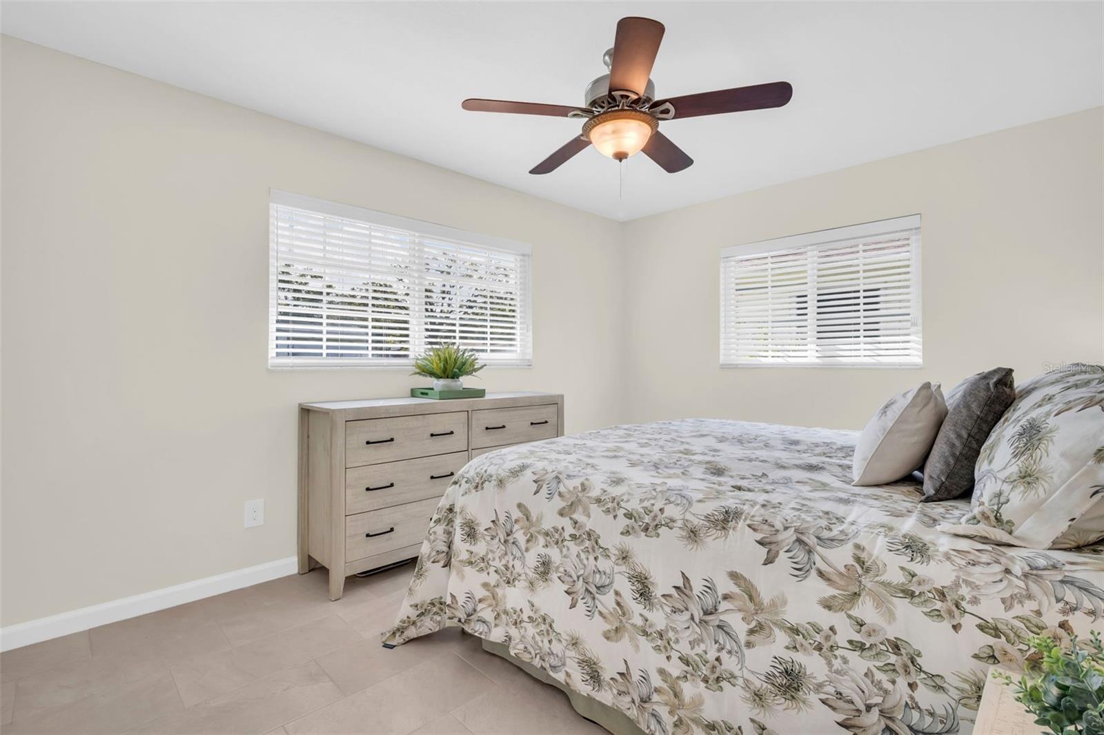 Serene primary bedroom complemented by natural light & insulated windows for peaceful rest~