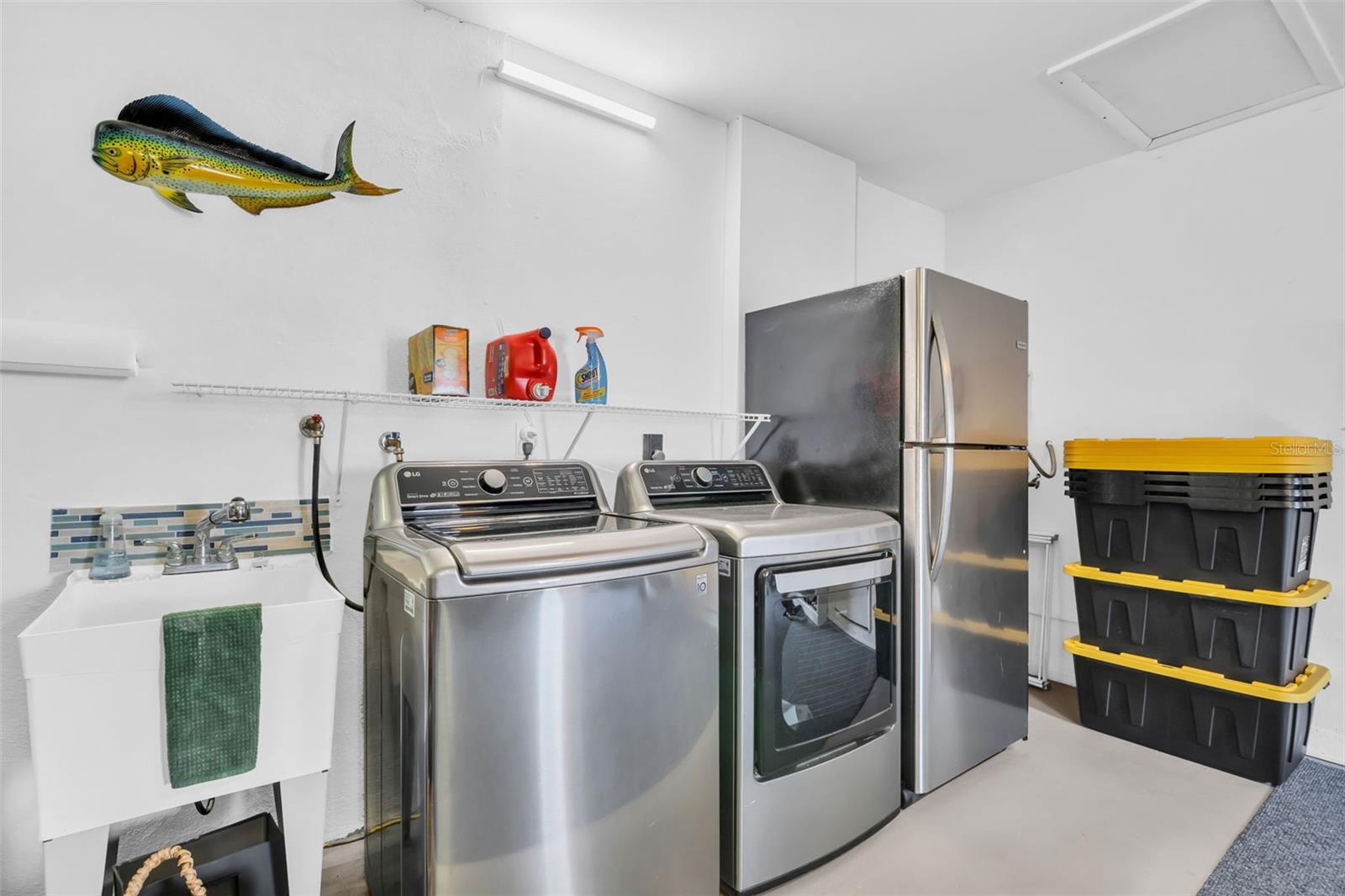 Newer laundry set, utility sink, & the extra fridge conveys with the house~