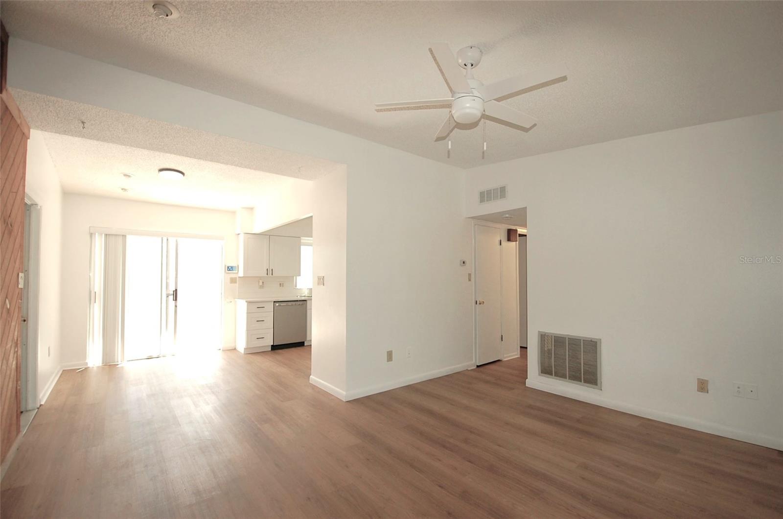 Living Room and dining room with cedar wood accent wall, new luxury vinyl flooring and vaulted ceilings.