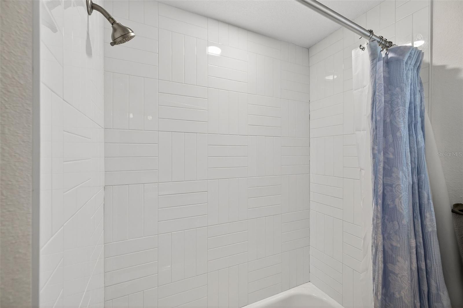 Large bathtub shower combo in guest bathroom