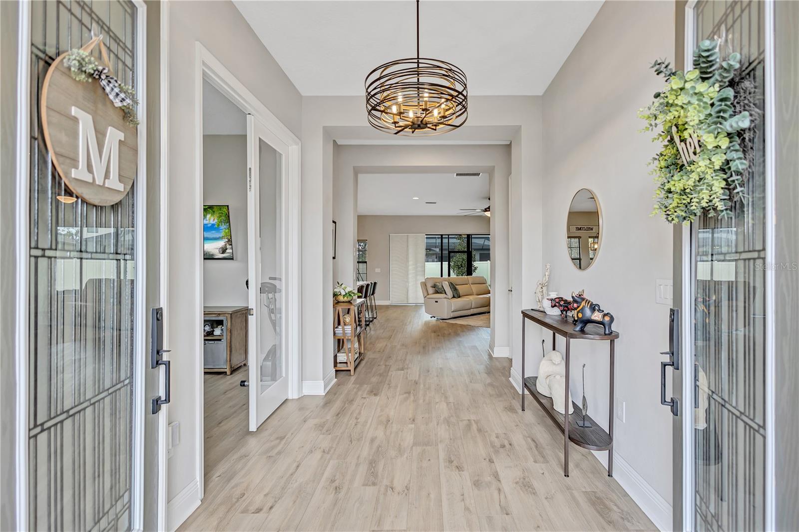 Double door entry opens to a light-filled space where designer details immediately set the tone.