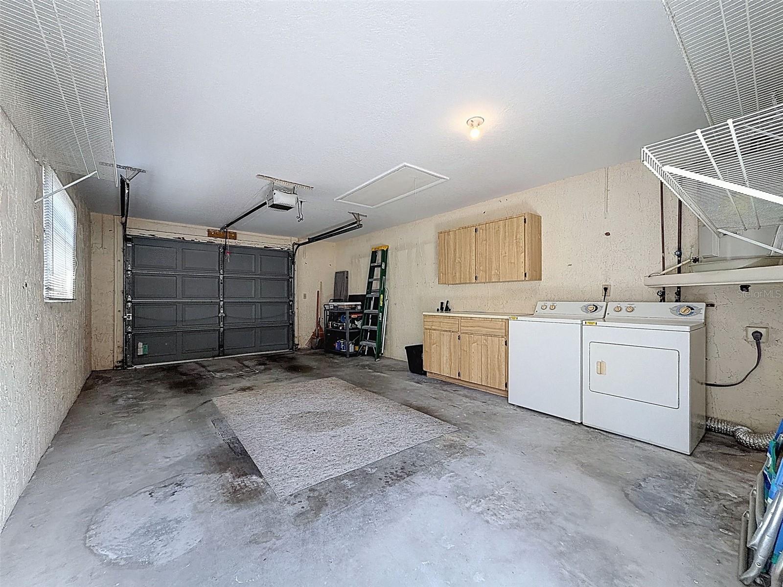 oversized detached garage with washer and dryer and storage cabinets.