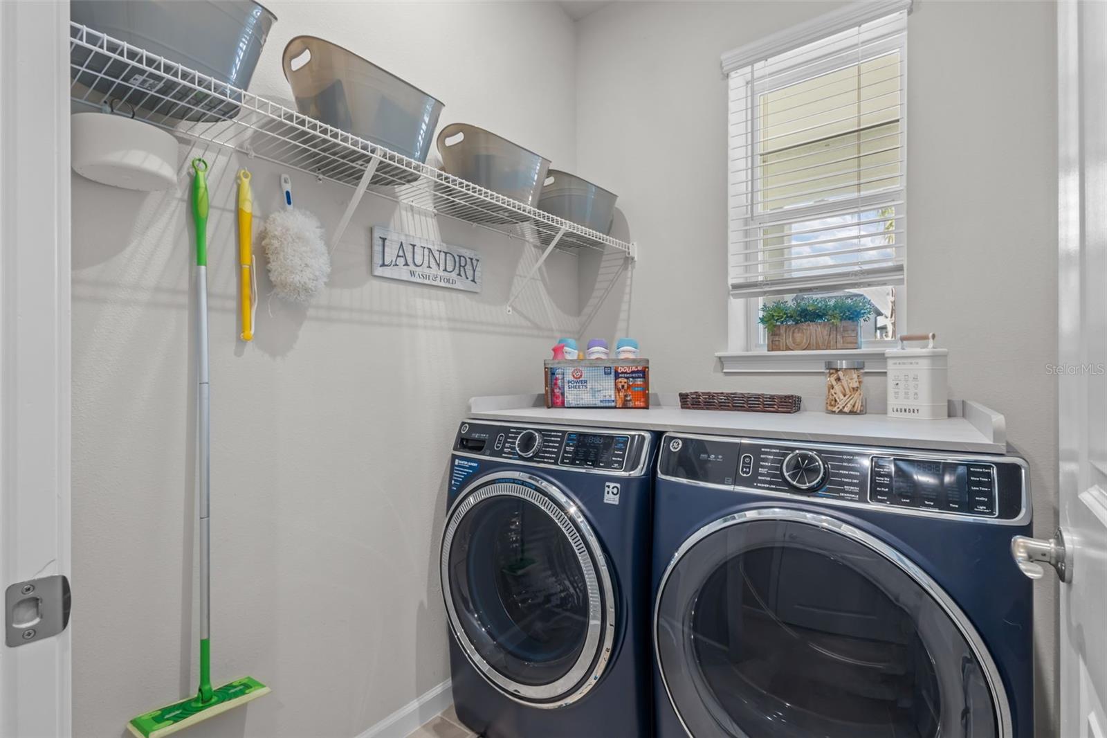 Dedicated laundry room with additional storage space.