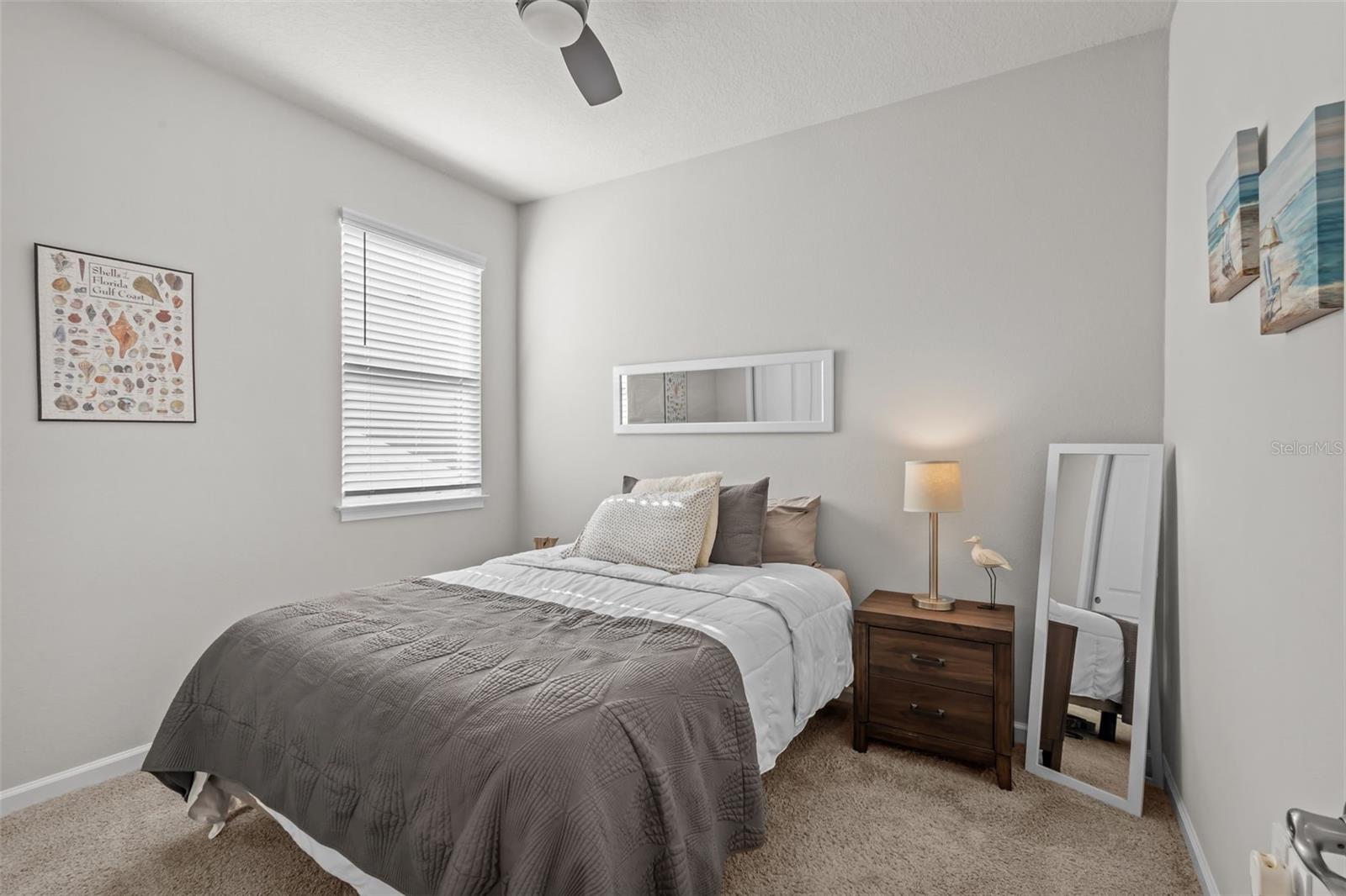 Secondary bedroom with ceiling fan and plenty of natural light.