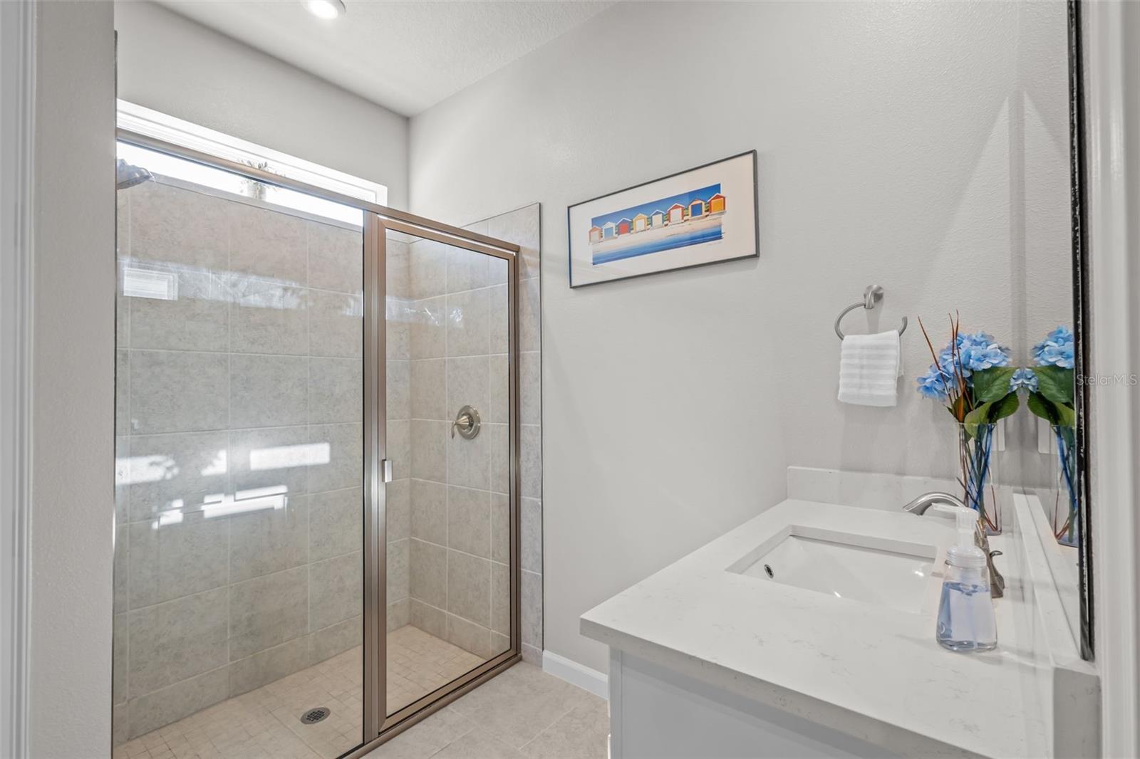 Primary bathroom featuring dual sinks and a well-designed layout.