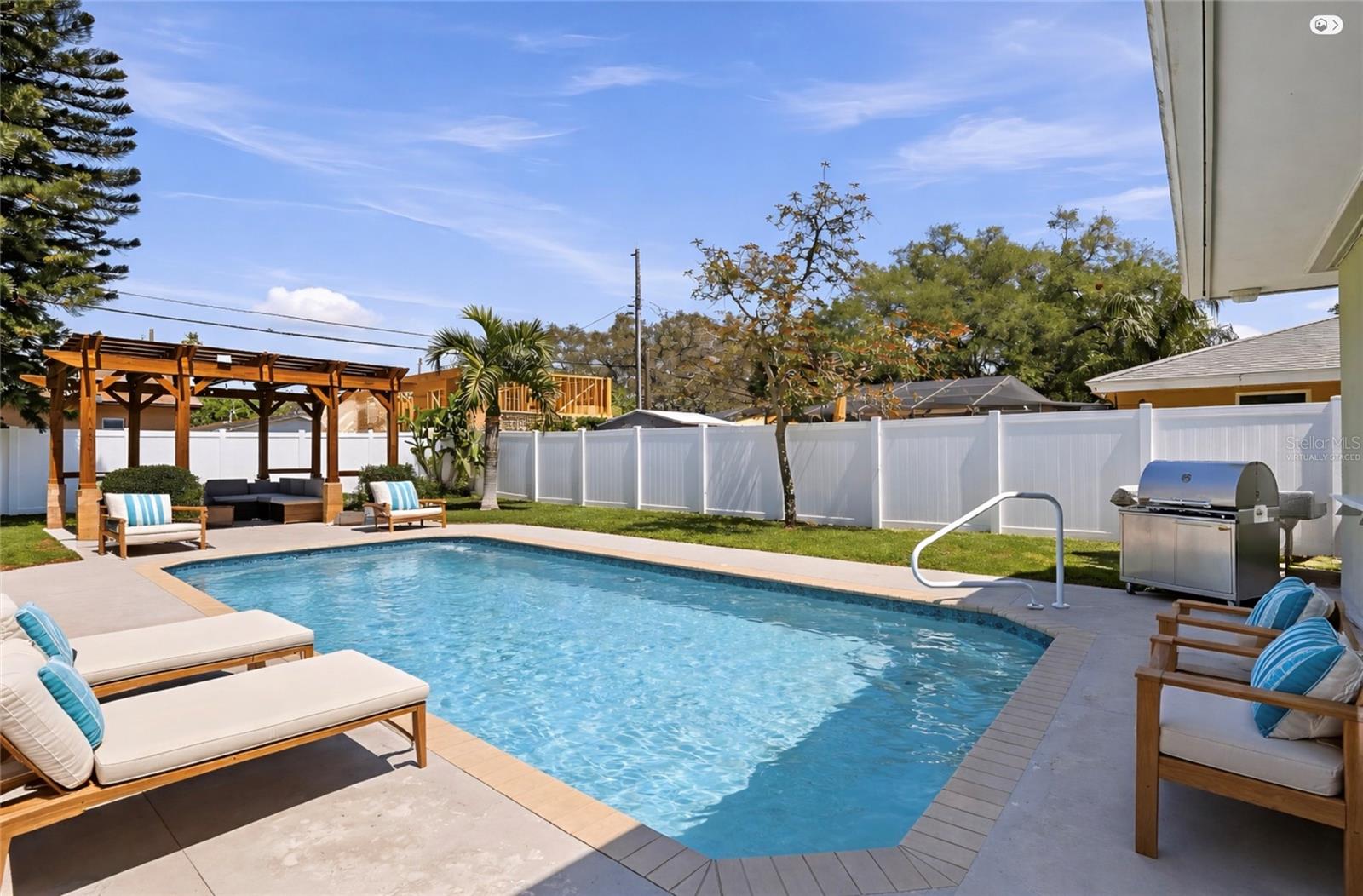 Private backyard oasis featuring a sparkling pool and ample lounging space