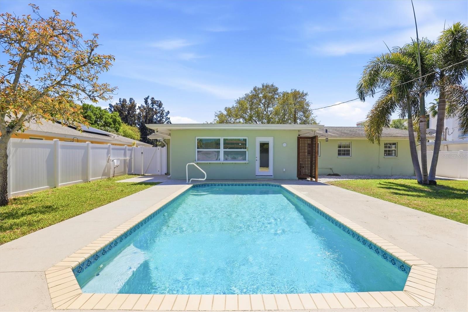 Private backyard oasis featuring a sparkling pool and ample lounging space