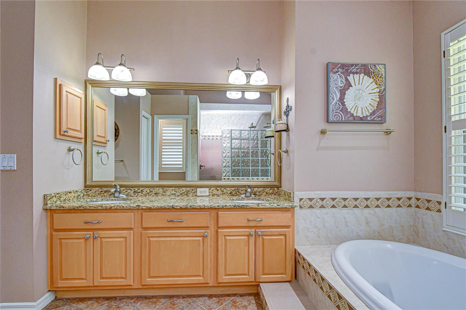 Luxurious en-suite with dual vanities and granite countertops.