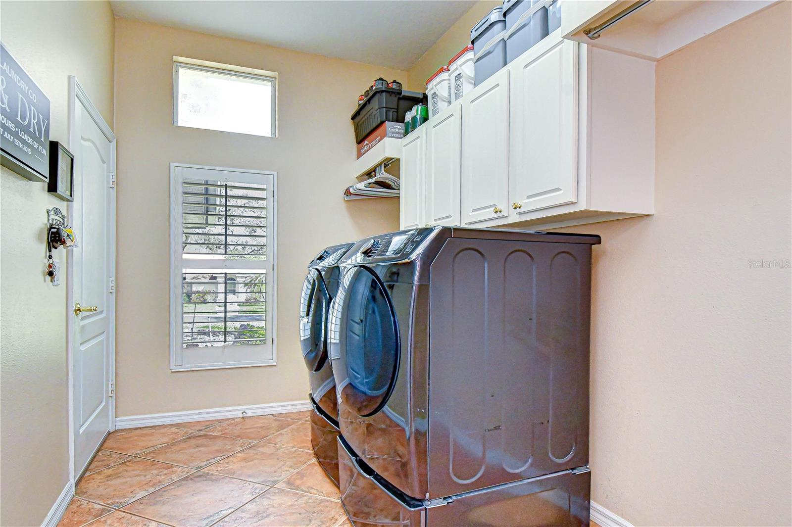 Well-equipped laundry room with cabinetry and utility sink.