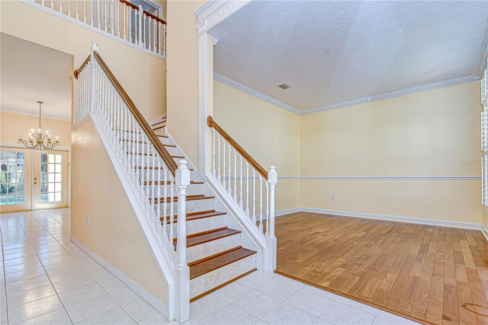 Light-filled foyer showcases a grand staircase.