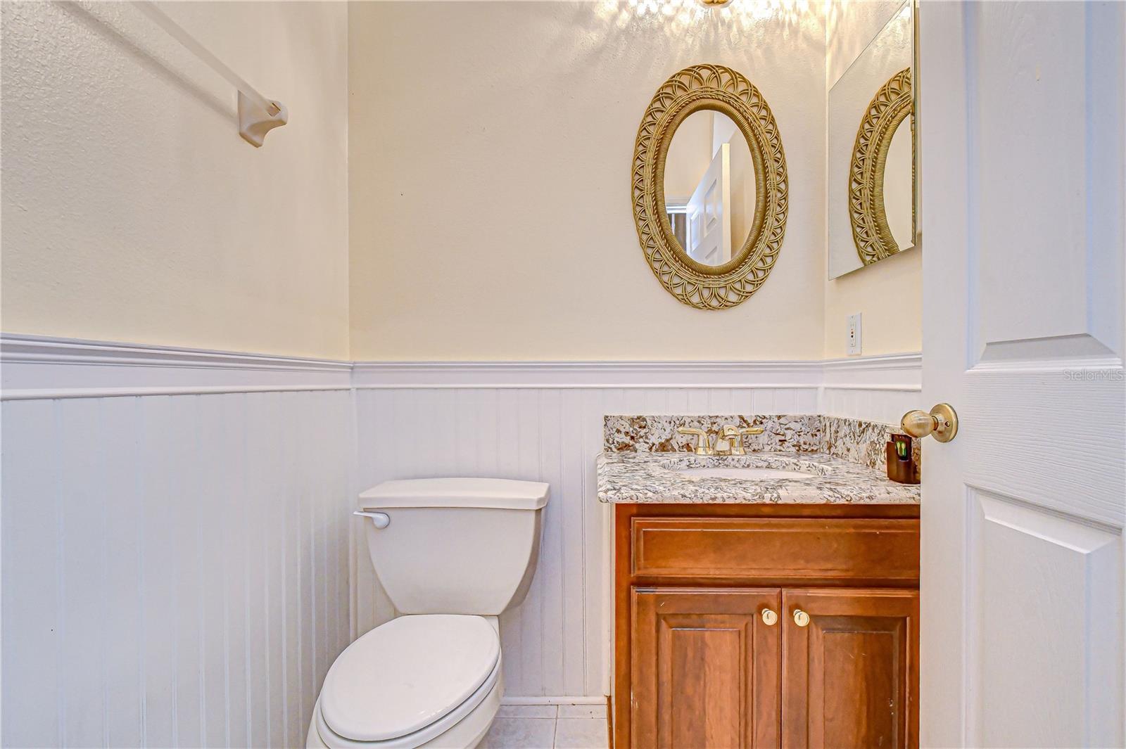 Stylish half bath with wainscoting.