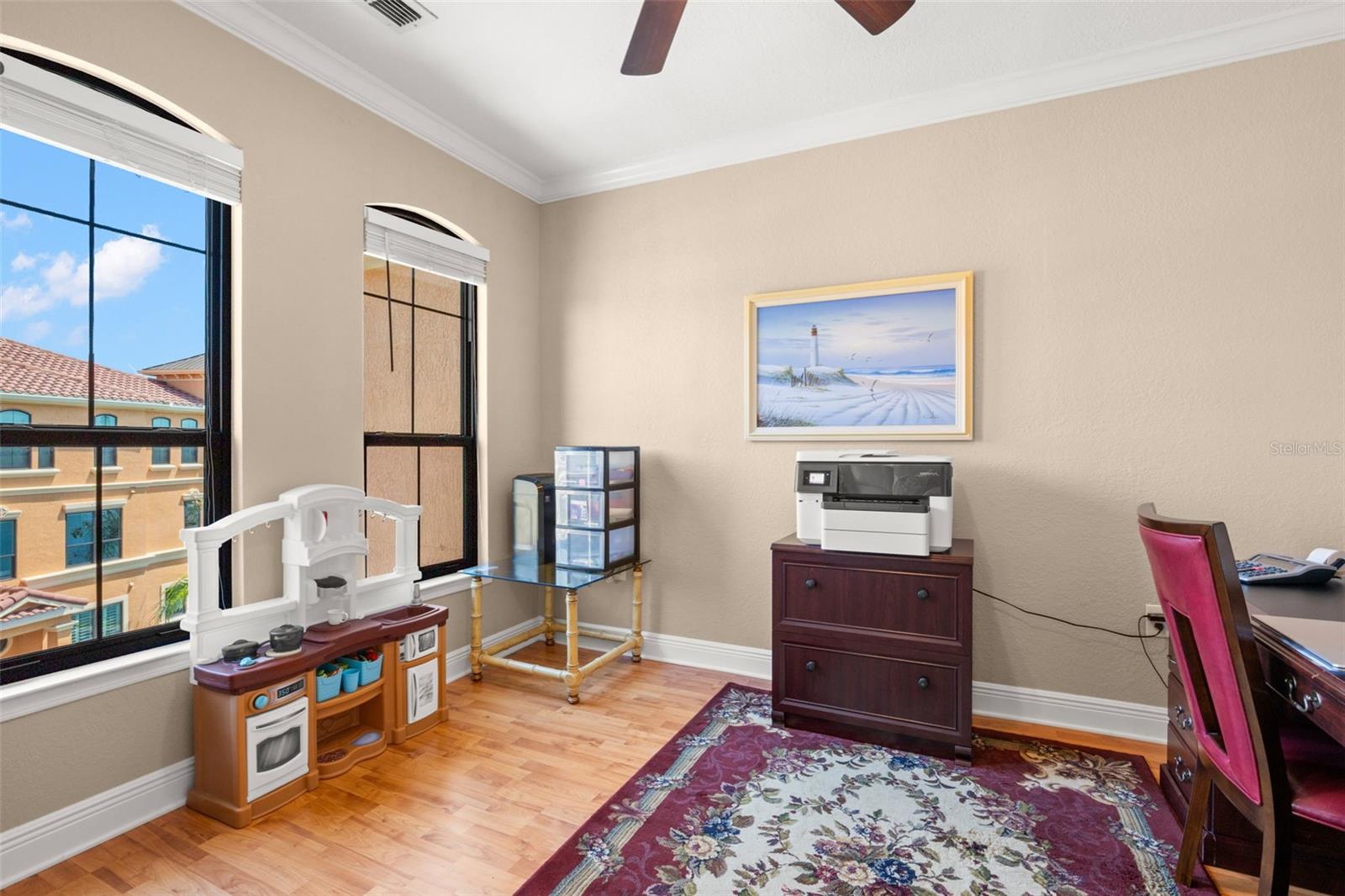 Bright and adaptable, this room with wood-look flooring and ceiling fan can easily function as a home office, den, or hobby room.