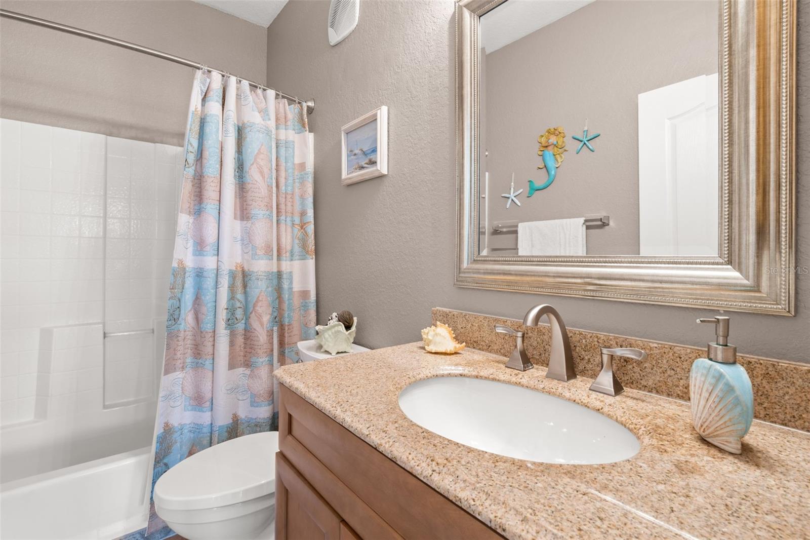A well-designed second bathroom with a spacious vanity and a tub/shower combination.