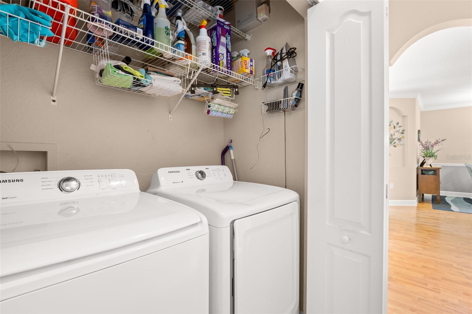 In-unit laundry with full-size washer and dryer and ample shelving to keep everyday essentials organized and within reach.
